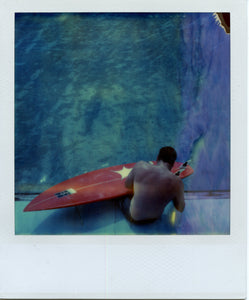 Polaroid image of a surfer repairing a board