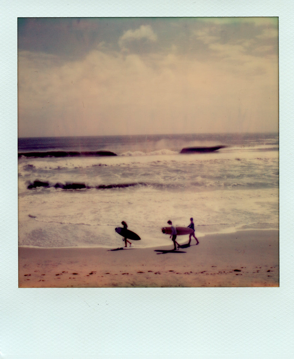 Polaroid image of three surfers at the Outer Banks