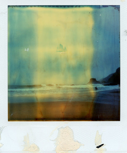Polaroid of a surfer on a stormy day at St AGnes