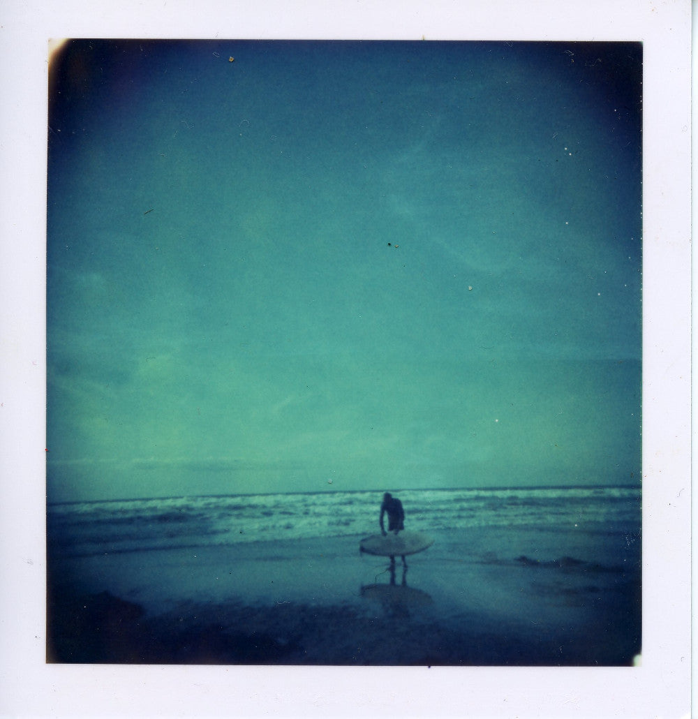 Polaroid image of surfer checking his board